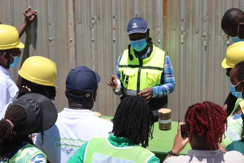 Esther Njeri showing Super Logs to visitors at the Utheri yard